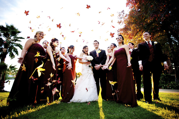 group portrait of the newlywed and guests tossing leaves into the air - wedding photo by top Orange County, California wedding photographers D. Park Photography